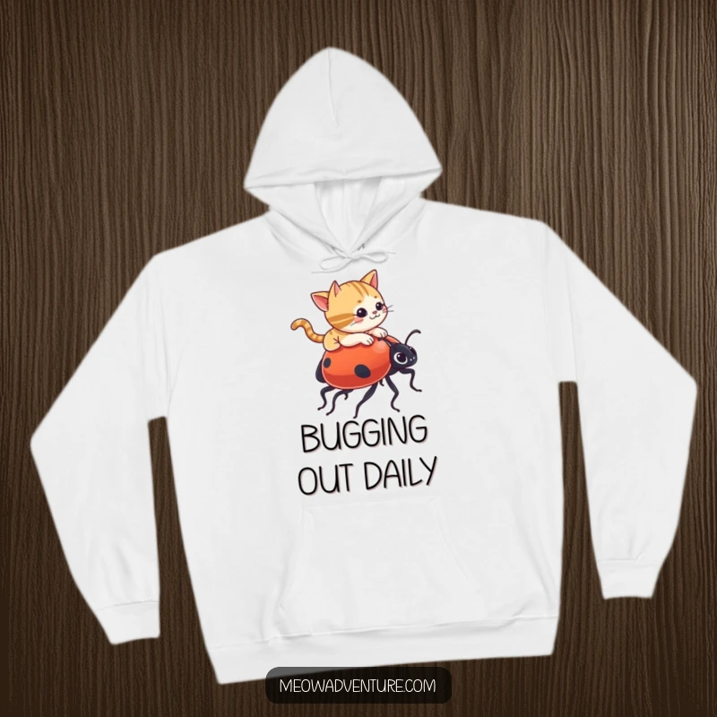 Funny hoodie with a mischievous cat adventurously riding a giant ladybug, designed for ultimate comfort and a hearty laugh.