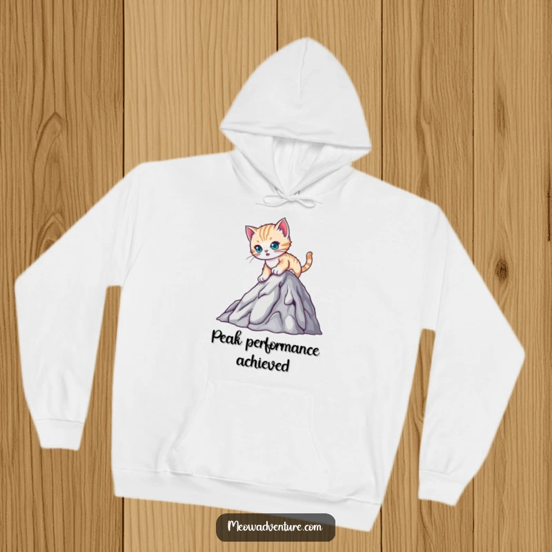 Funny hoodie featuring a determined kitten climbing a miniature mountain, perfect for embracing challenges with warmth and humor.