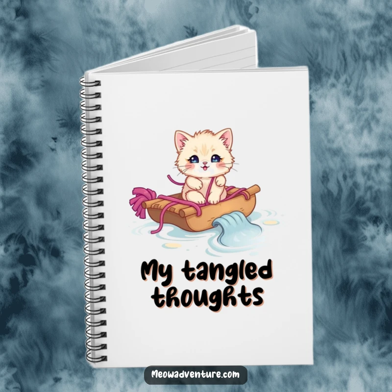 Funny fluffy kitten on a yarn raft sailing on yarn, featured on the cover of a lined notebook.