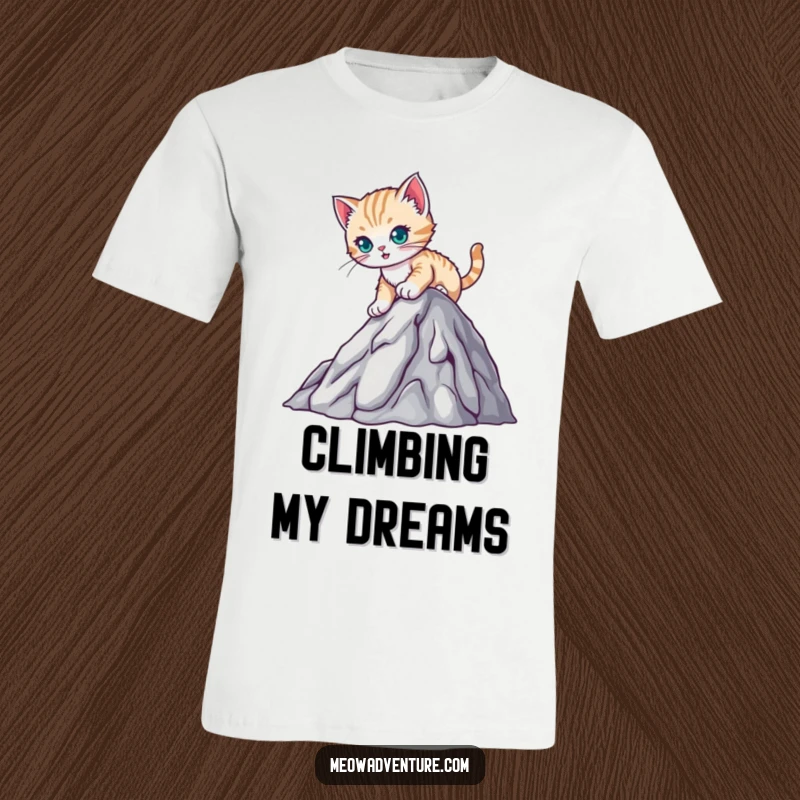 Funny t-shirt with a determined kitten climbing a small mountain, representing strength and cute perseverance, a great gift.
