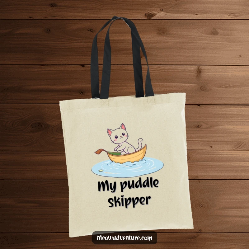 Funny tote bag depicting an adventurous cat sailing on a leaf boat, ideal for carrying essentials with a spirit of exploration.